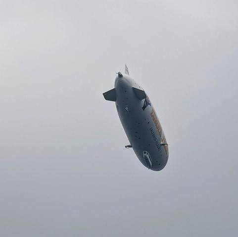Ein Zeppelin von schräg hinten unten aufgenommen. Seitliche Aufschrift: "Europapark". Hintergrund: Graue Wolkendecke